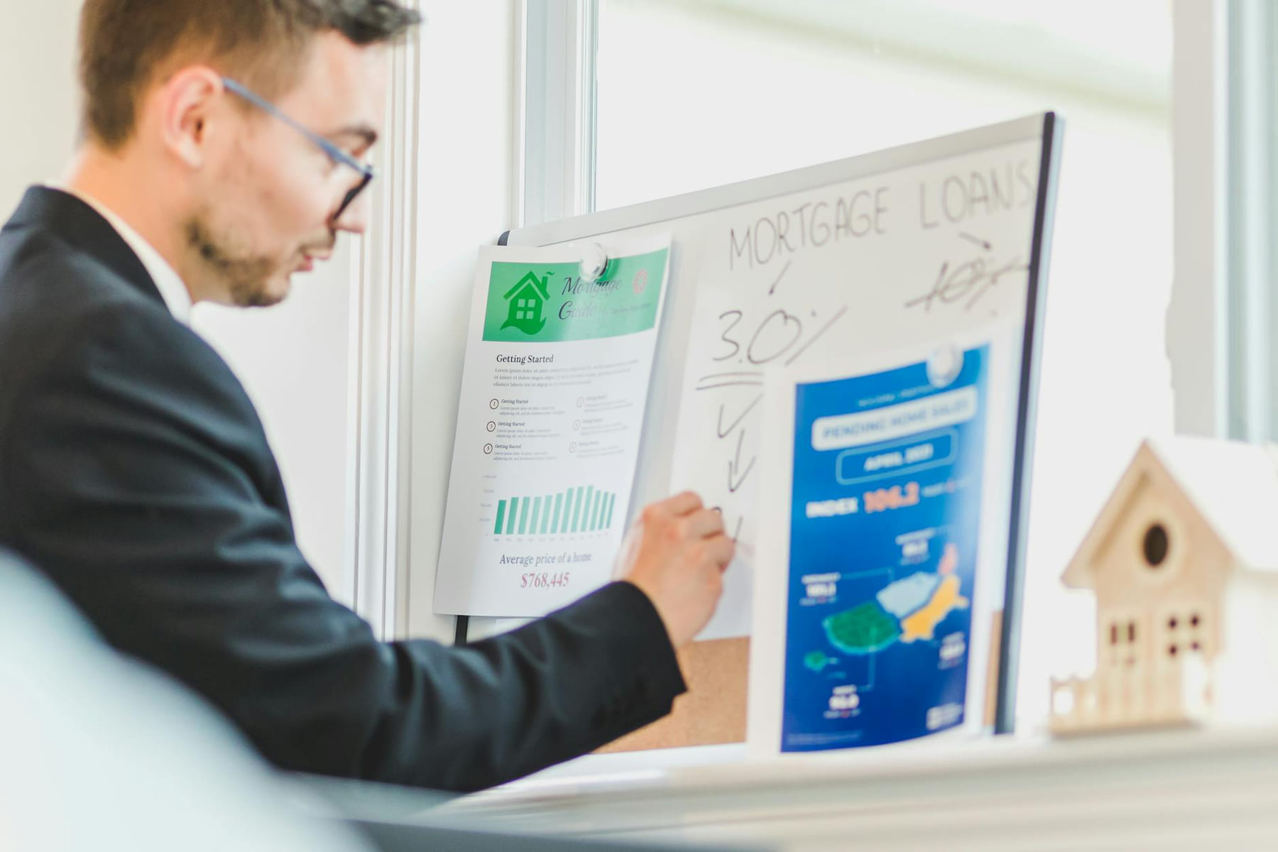 Real estate agent analyzing mortgage loan details on a whiteboard in an office setting. on The Smart Home Buyer