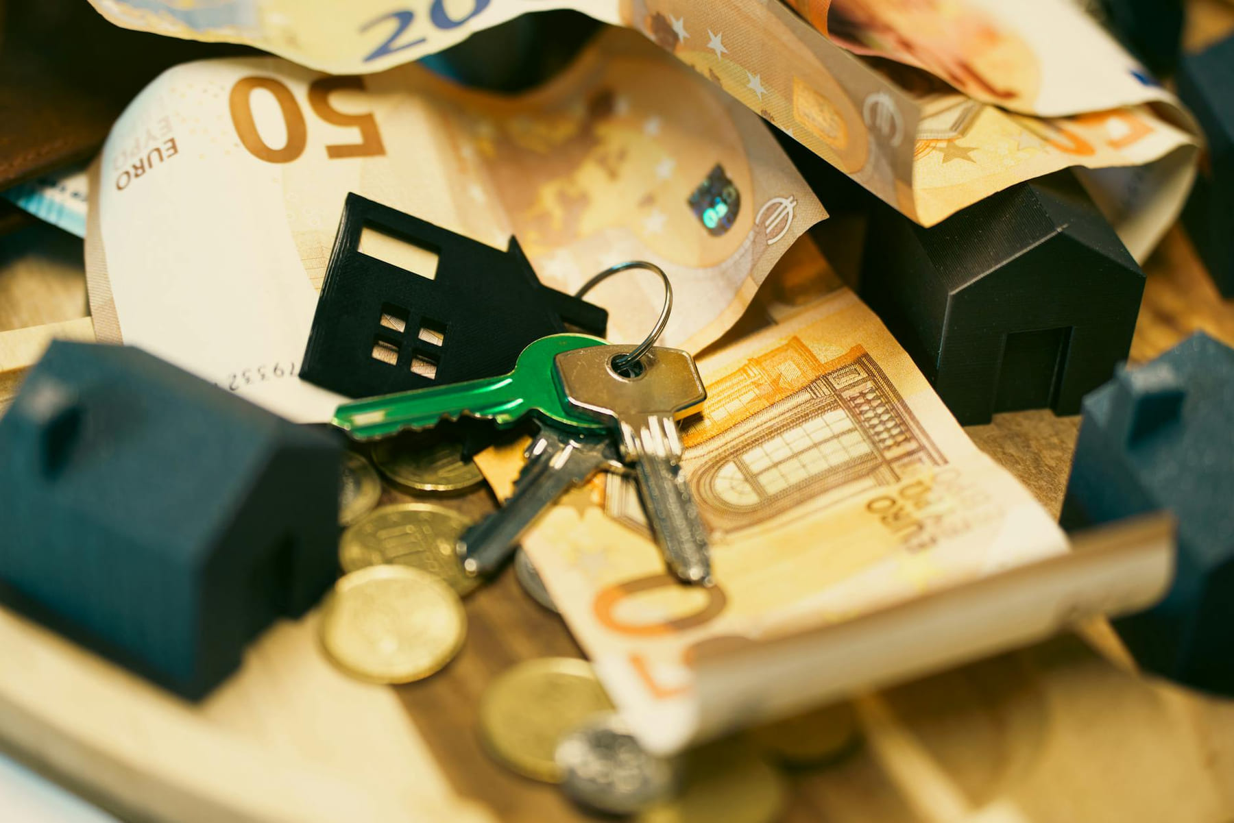 Euro currency with house keys and miniature models, symbolizing real estate investment. on The Smart Home Buyer