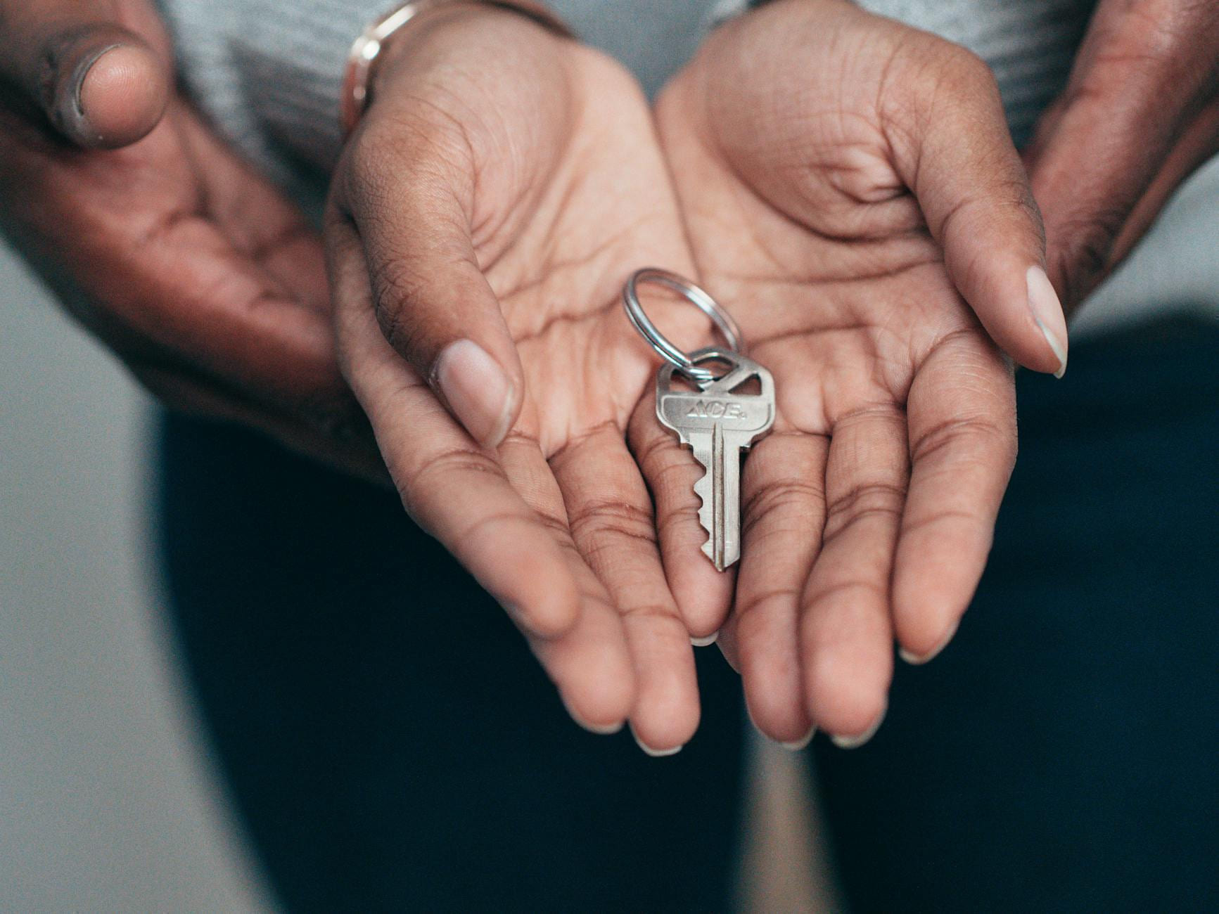 Close-up of hands holding a key, symbolizing homeownership, real estate, and property investment. on The Smart Home Buyer