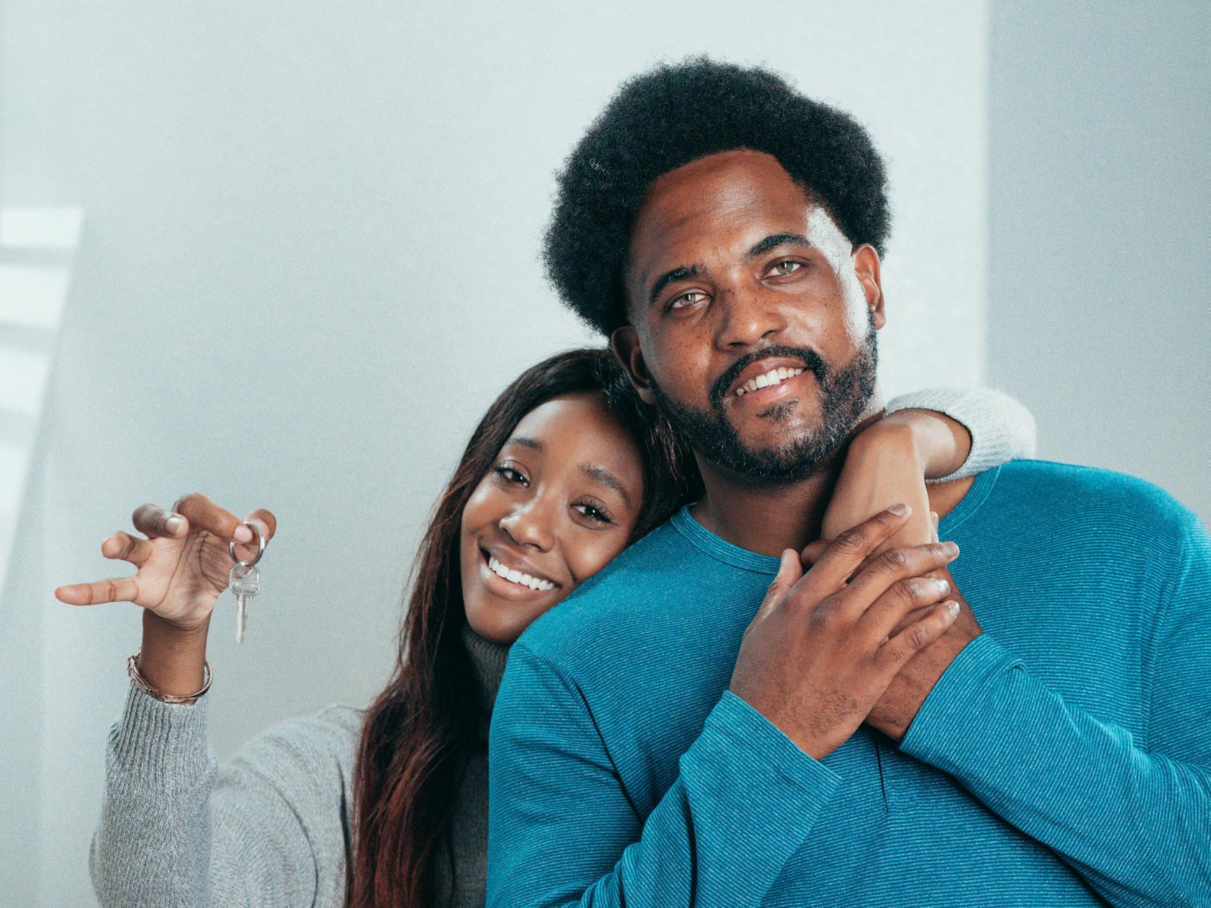Joyful couple proudly holding keys to their new home, symbolizing fresh beginnings. on The Smart Home Buyer