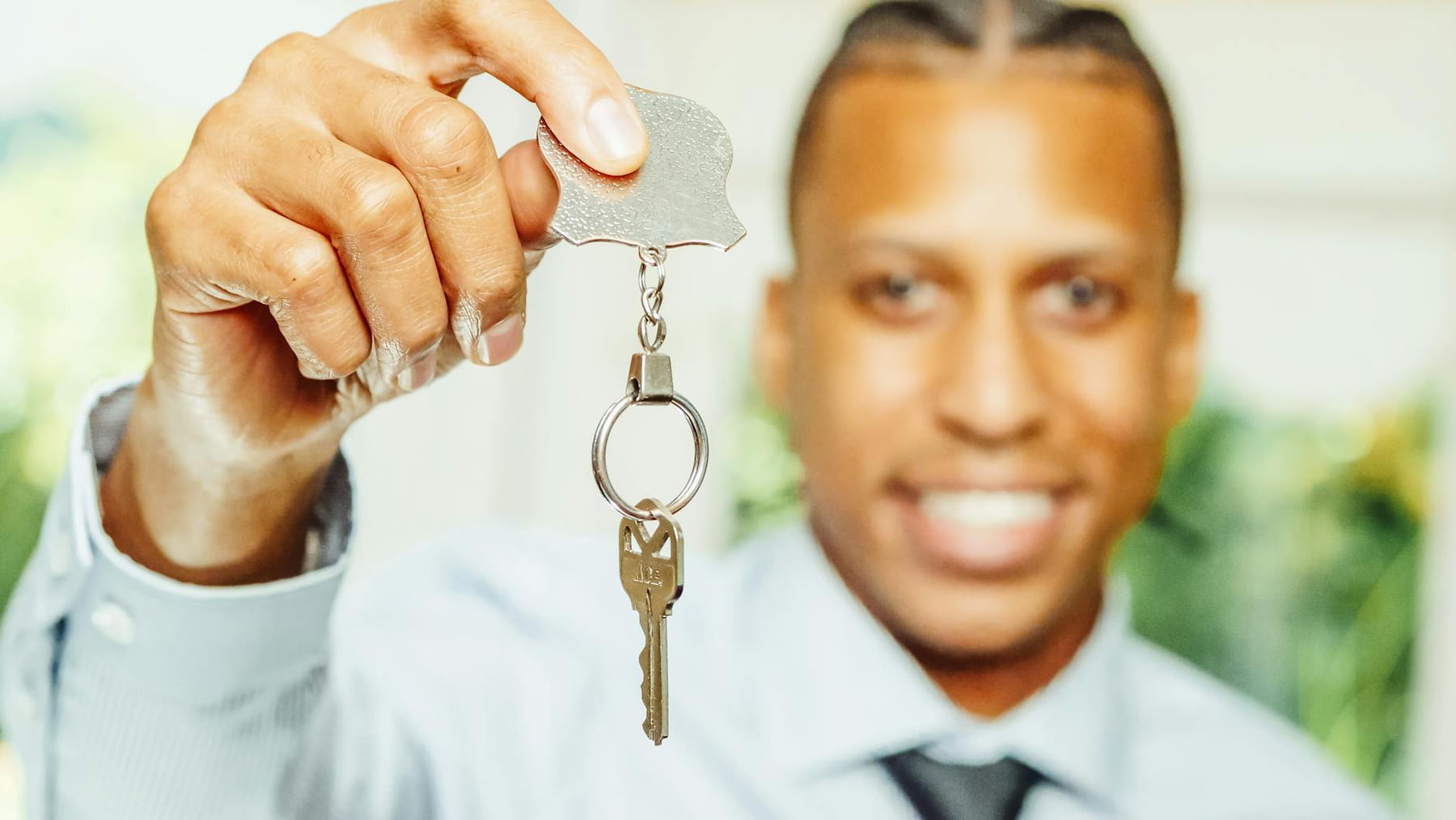 A cheerful real estate agent presents a key, symbolizing a new home purchase. on The Smart Home Buyer