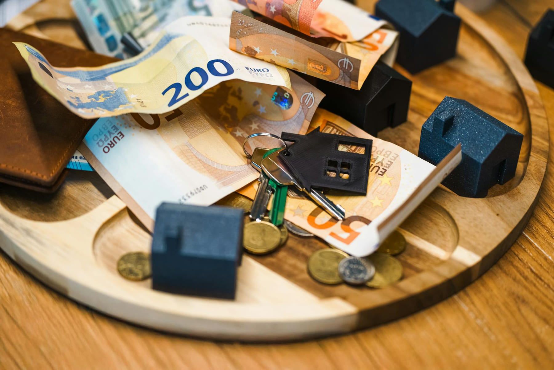 Euro currency, keys, and miniature houses symbolize real estate and finance concepts. on The Smart Home Buyer