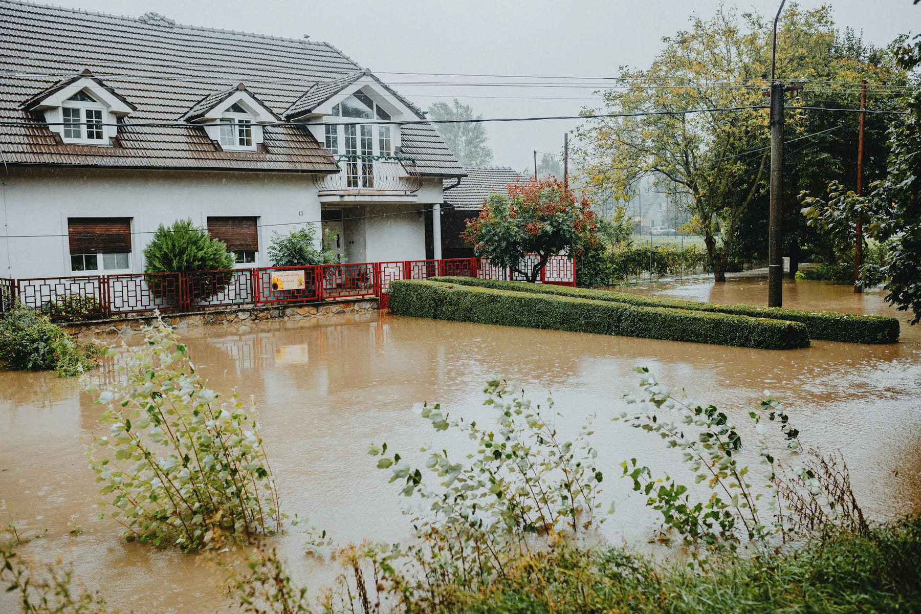 A suburban house surrounded by floodwaters after heavy rain, showing impact of natural disaster. on The Smart Home Buyer